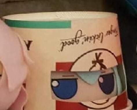 Blue haired doll with a papel bucket on its head